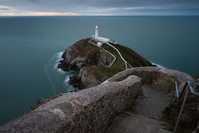 High angle view of lighthouse amidst sea during sunset