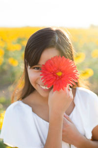 Portrait of woman holding red flower