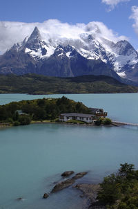 Scenic view of lake by snowcapped mountains against sky