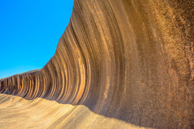 View of rock formation on land against clear blue sky