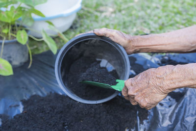 Cropped hand of person watering plants