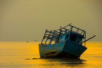 Abandoned ship in sea against clear sky