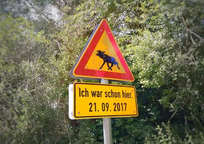 Close-up of road sign against trees