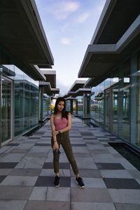 Portrait of young woman standing against sky