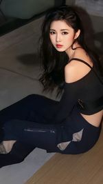 Portrait of young woman sitting on floor