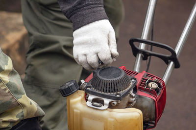 Midsection of person holding harrow