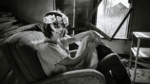 Portrait of woman sitting in abandoned house