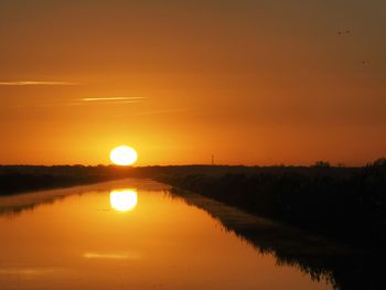 Scenic view of silhouette landscape against orange sky