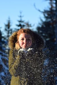 Portrait of woman playing with snow