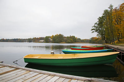 Boats moored in lake against sky