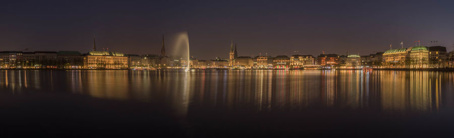 Illuminated buildings in city at waterfront