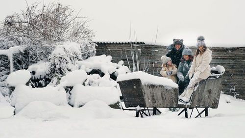 Winter family fun. throwing snow. happy, laughing, playful family of 4 is enjoying 