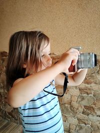 Full length of woman standing against wall at home