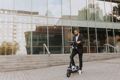 Businessman riding scooter