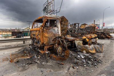 Burnt military vehicles of russian soldiers on the bridge across the river. rusty cars. 