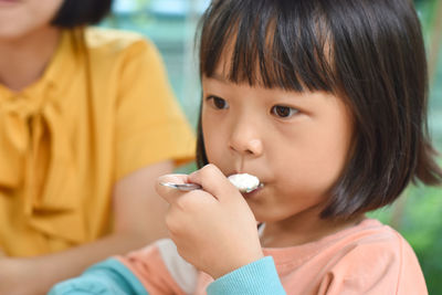 Close-up of child girl eating ice cream in outdoor cafe. selective focus