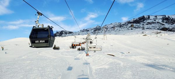 Overhead cable car in snow covered mountains