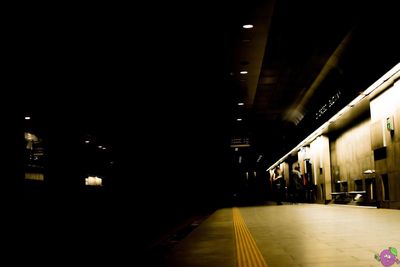 Empty illuminated railroad station platform at night