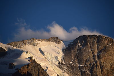 Low angle view of snowcapped mountains against sky