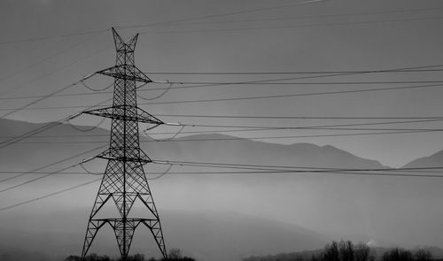 Low angle view of electricity pylon against sky