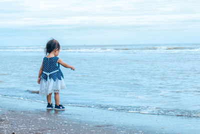 Full length of boy on beach against sky