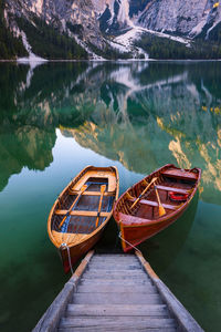 Boat moored on lake against mountain