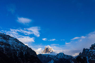 Scenic view of snowcapped mountains against blue sky