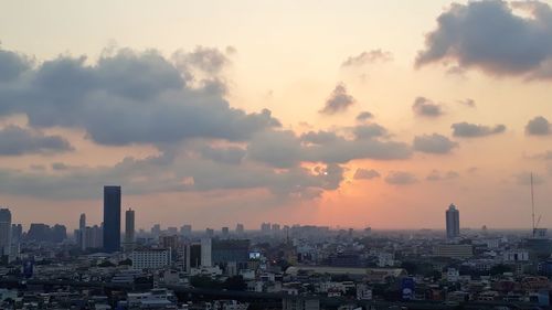 Buildings in city against sky during sunset