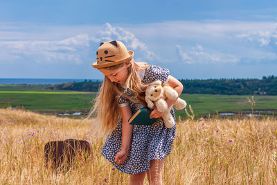 
child girl in straw hat dress sitting vintage suitcase reading bookcute kid toy looking at notebook