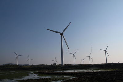 Low angle view of windmills against clear sky