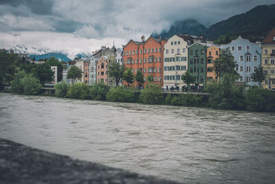 River by buildings against sky