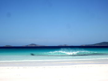 Scenic view of beach against clear blue sky