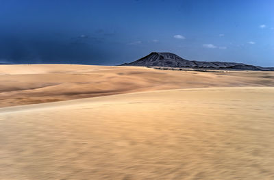 View of desert against cloudy sky