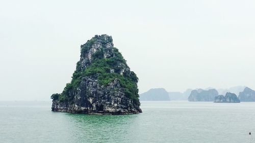 Rock formations in sea against clear sky