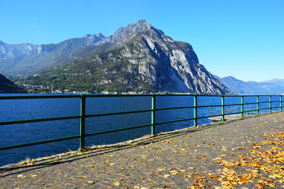 Scenic view of sea and mountains against clear blue sky