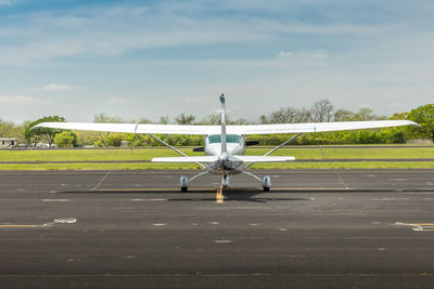 Airplane on runway against sky