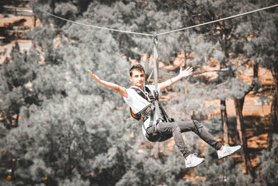 Low angle view of man hanging on rope