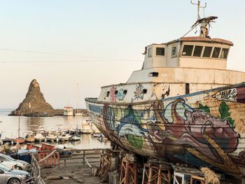 Fishing boats moored on sea against buildings