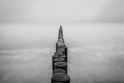 View of groyne in sea against sky