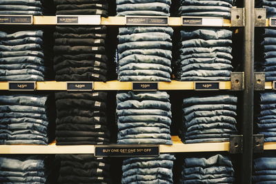 Full frame shot of jeans arranged on shelves for sale at store