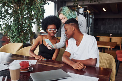 Group of multi ethnic people with alternative girl with green hair is working together