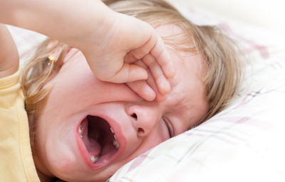 Close-up of girl crying while lying on bed