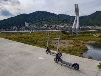 Bicycle on bridge over river against sky