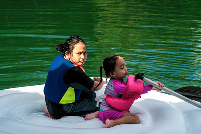 Mother and girl sitting in water