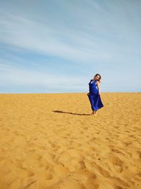 Man standing on sand at beach against sky