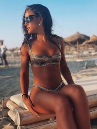 Young woman wearing sunglasses sitting on beach