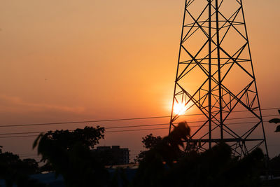 Silhouette electricity pylon against sky during sunset