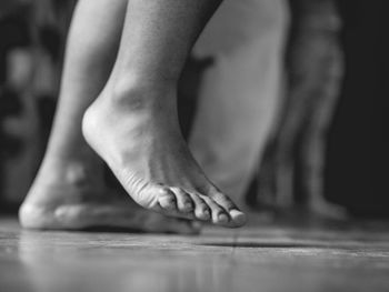 Low section of woman dancing barefoot