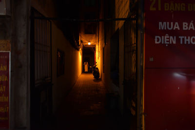 Illuminated street amidst buildings in city at night