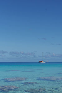 Sailboat in sea against blue sky